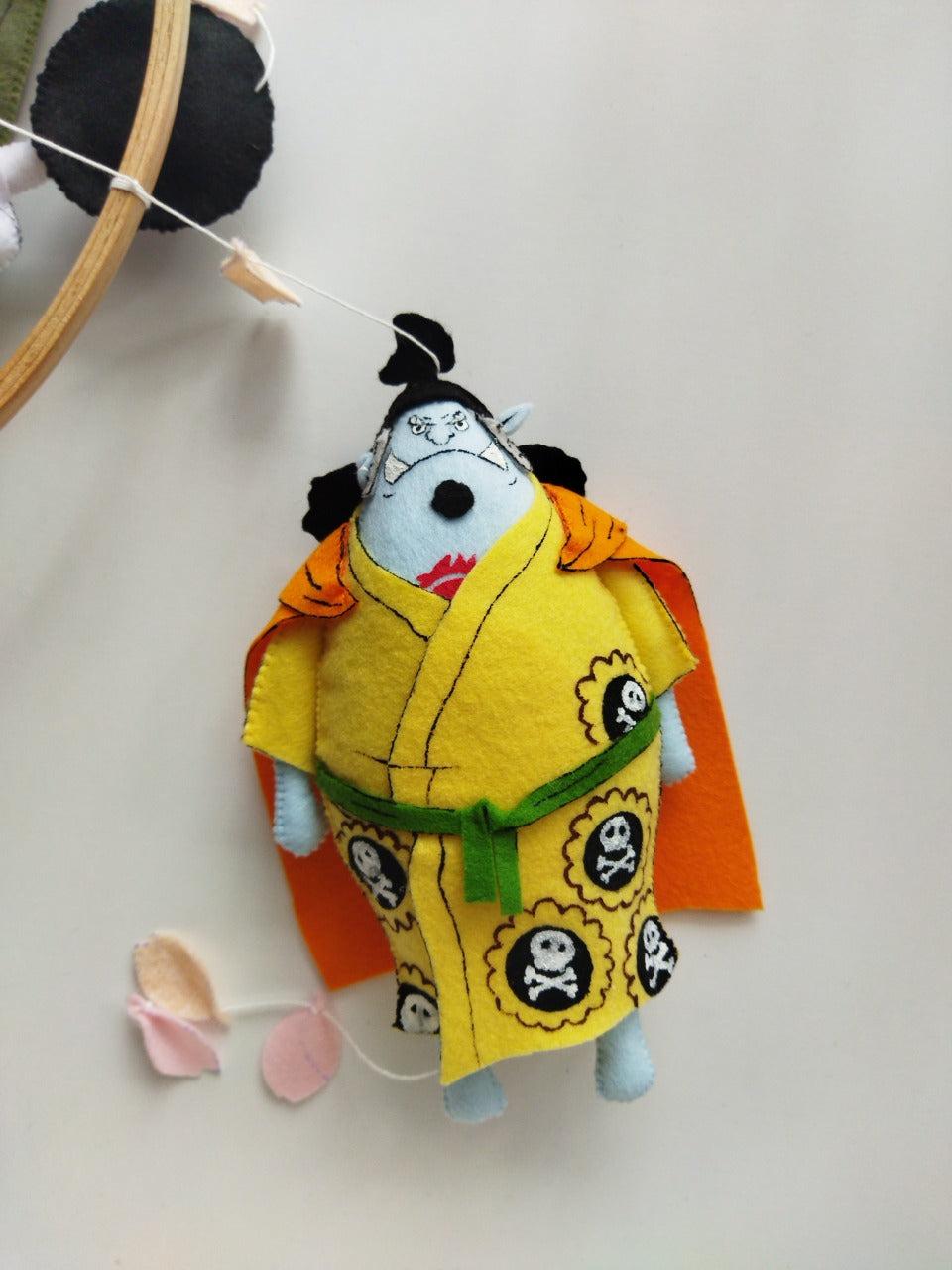 Primo piano del personaggio Jinbe in feltro versione Wano su giostrina neonato per culla, regalo nascita artigianale