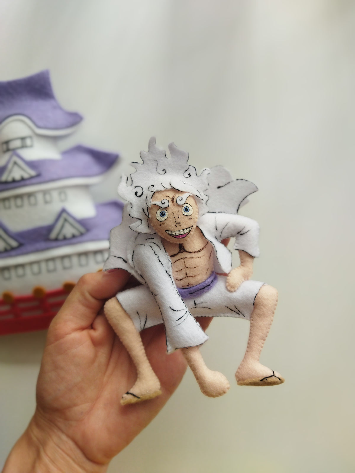 Primo piano di Luffy Gear 5 in feltro su giostrina per neonati, idea regalo nascita artigianale