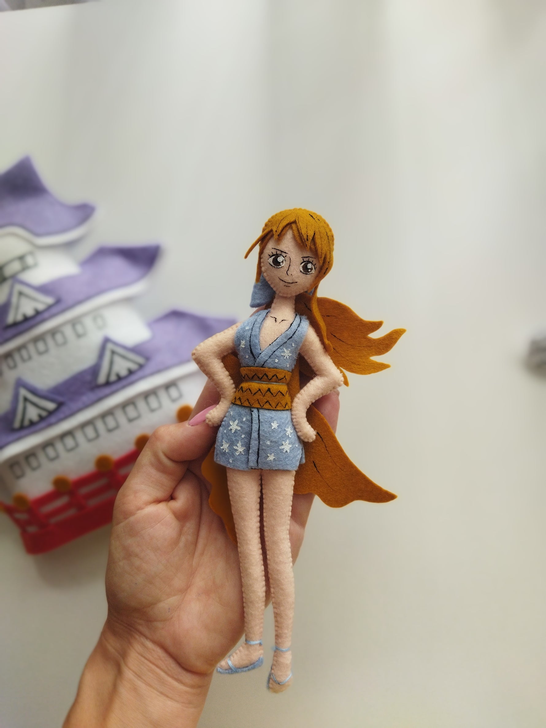 Primo piano del personaggio Nami in feltro versione Wano su giostrina neonato per culla, regalo nascita artigianale