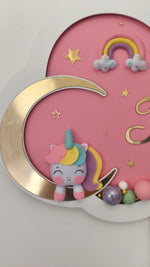 Primo piano peluche unicorno pastello su luna, arcobaleno e stelle dorate