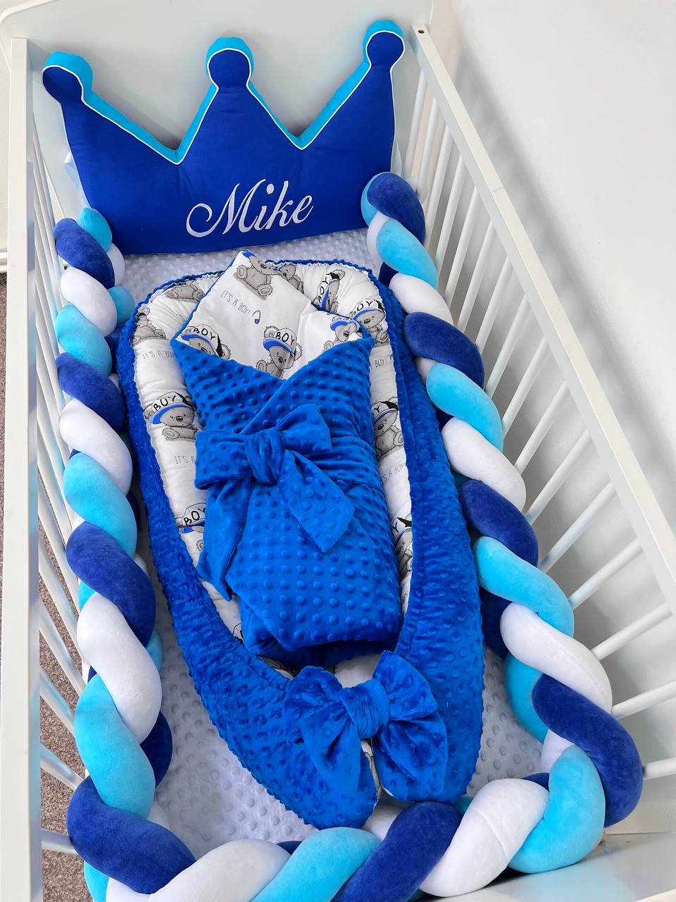 Set culla azzurro e blu con paracolpi a treccia, cuscino corona, riduttore neonato e coperta sacco nanna stampata con orsetti.