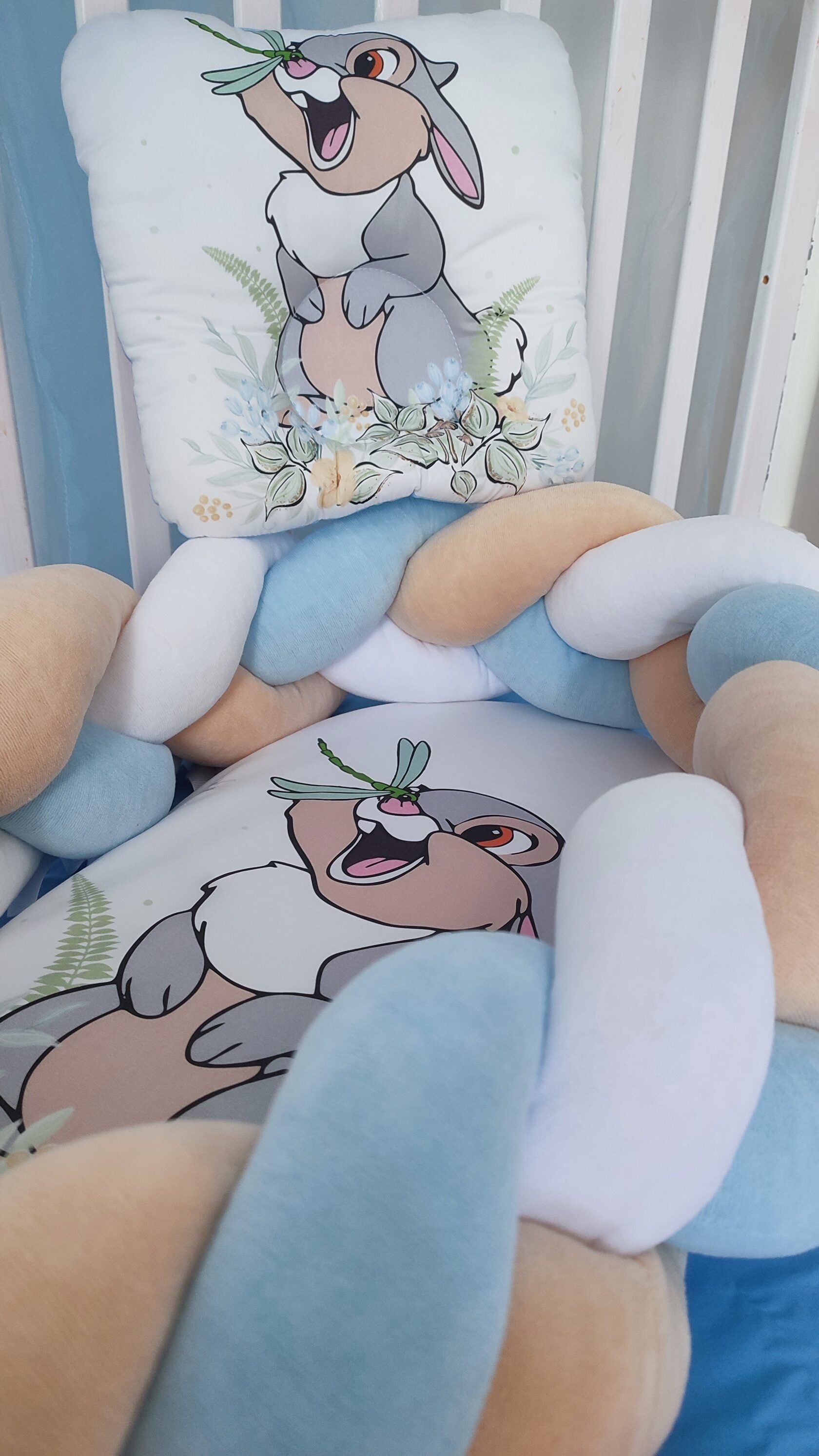 Primo piano riduttore nido neonato intrecciato con cuscino fantasia coniglietto azzurro beige e bianco