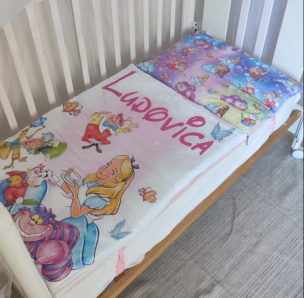 Sacco a pelo da lettino rosa e bianco a tema Alice nel Paese delle Meraviglie con cuscino colorato integrato e nome stampato.