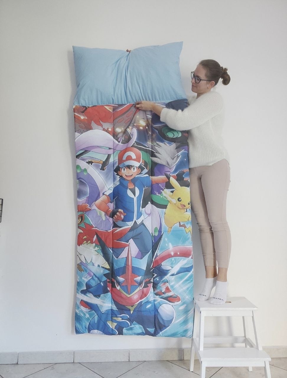 Sacco a pelo per bambini a tema Pokémon con stampa colorata di Ash, Pikachu e Greninja, completo di cuscino azzurro integrato.