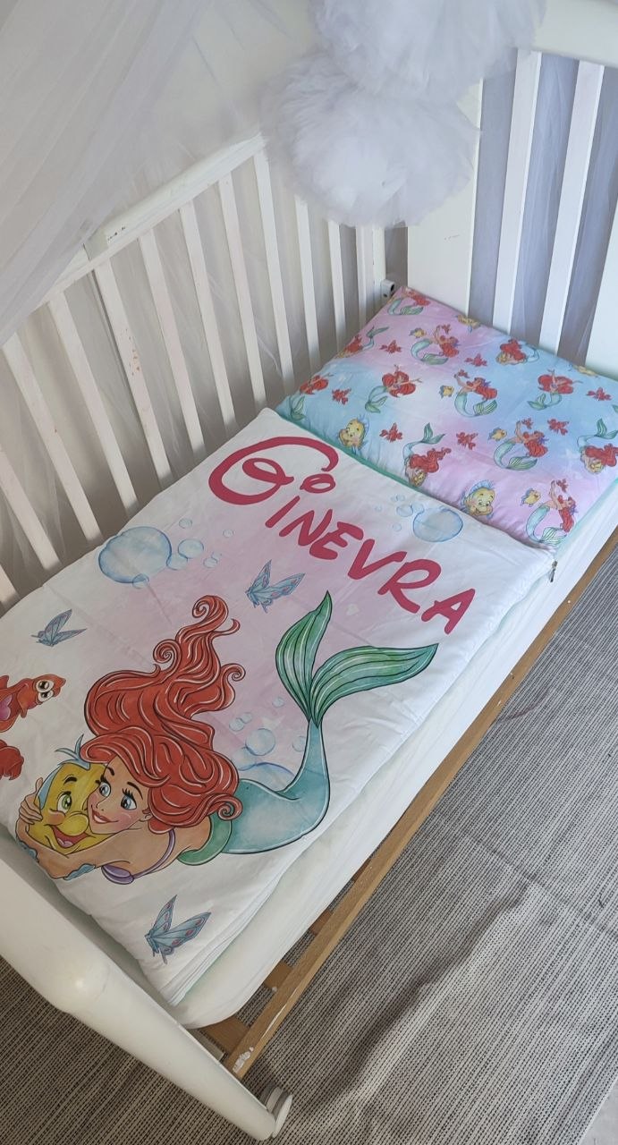 Sacco a pelo da lettino per bambini a tema Sirenetta con stampa di Ariel, Flounder e farfalle blu su sfondo bianco.