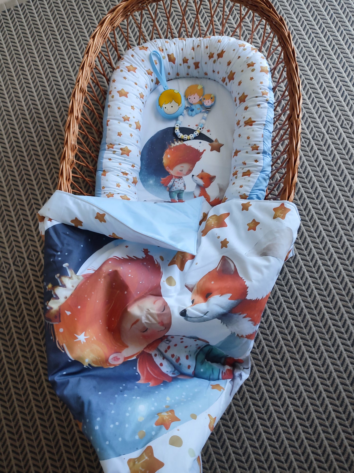 Set neonato Piccolo Principe in culla di vimini, riduttore nido azzurro e copertina coordinata.