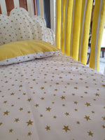 Set lenzuola lettino neonato con stampa stelle oro, abbinato a paracolpi americani gialli e cuscino coordinato, corredo completo cameretta unisex