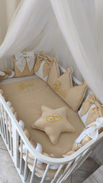Set lettino neonato beige e oro con paracolpi a treccia, baldacchino, cuscino corona personalizzato e stella.