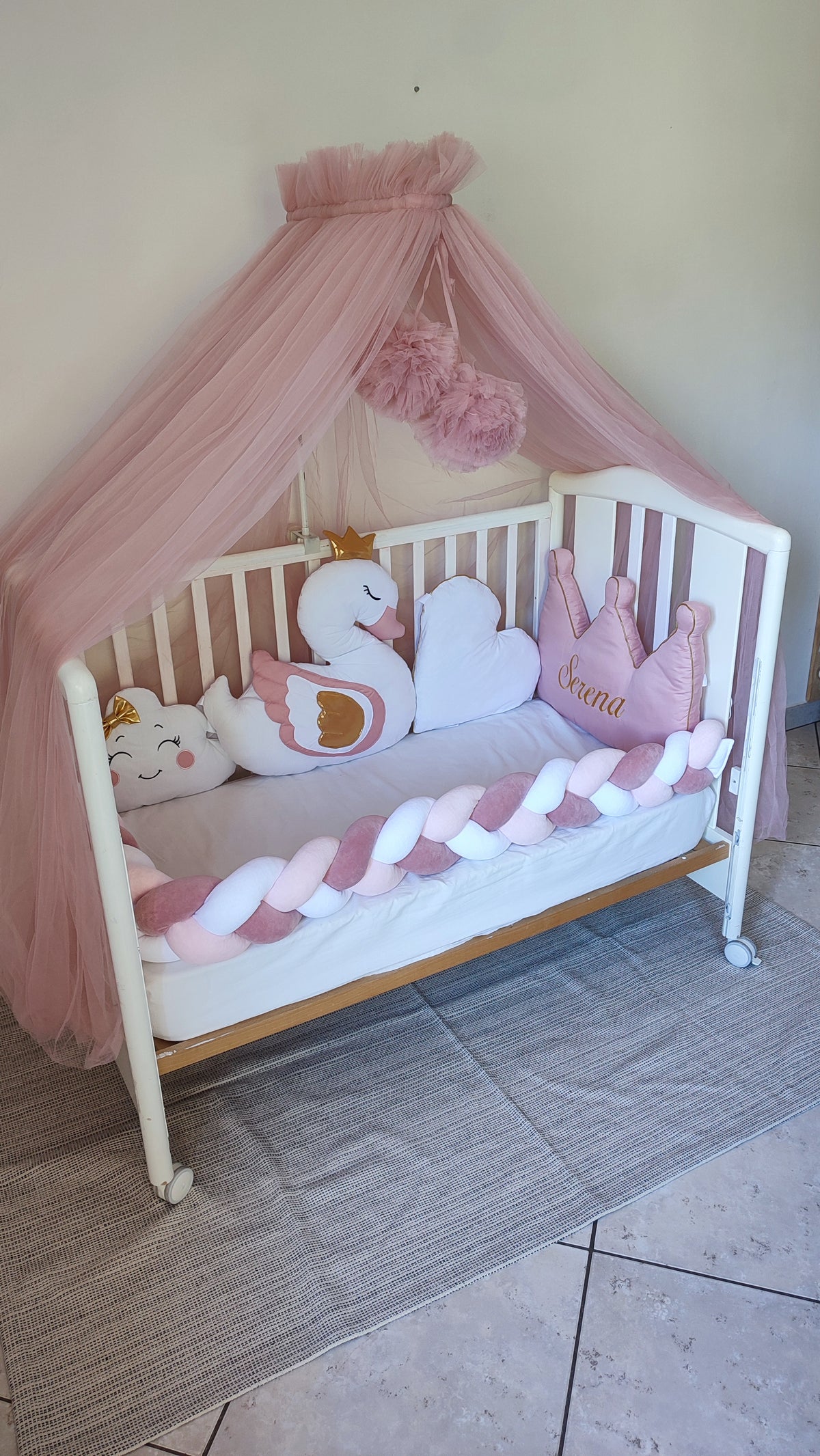 Lettino bimba rosa con paracolpi a treccia, velo baldacchino e cuscini a forma di cigno e corona 