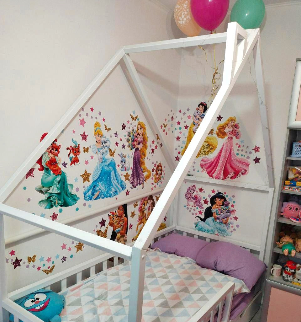 Decorazioni adesive da parete per cameretta bimba con Cenerentola, Ariel, Rapunzel, Aurora e Jasmine circondate da stelline colorate.