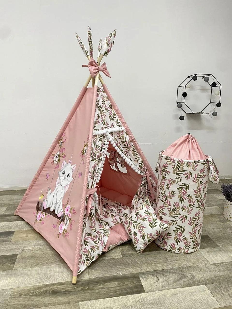 Tenda teepee bambini rosa con gatto bianco dipinto a mano, foglie decorative, pompon bianchi e cestino coordinato