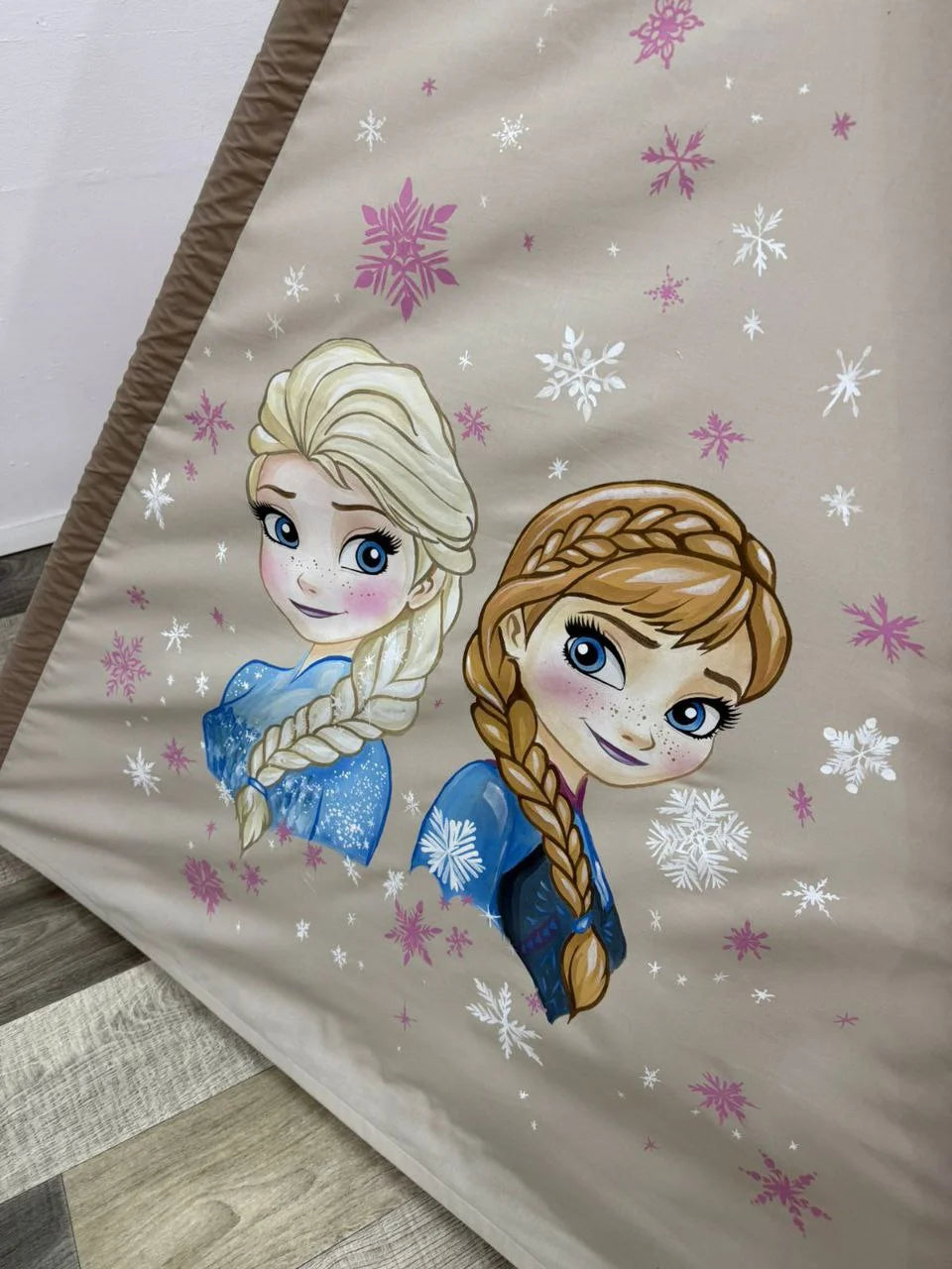 Dettaglio pittura a mano su tenda teepee bambini in cotone tortora con fiocchi di neve rosa e decorazioni fiaba
