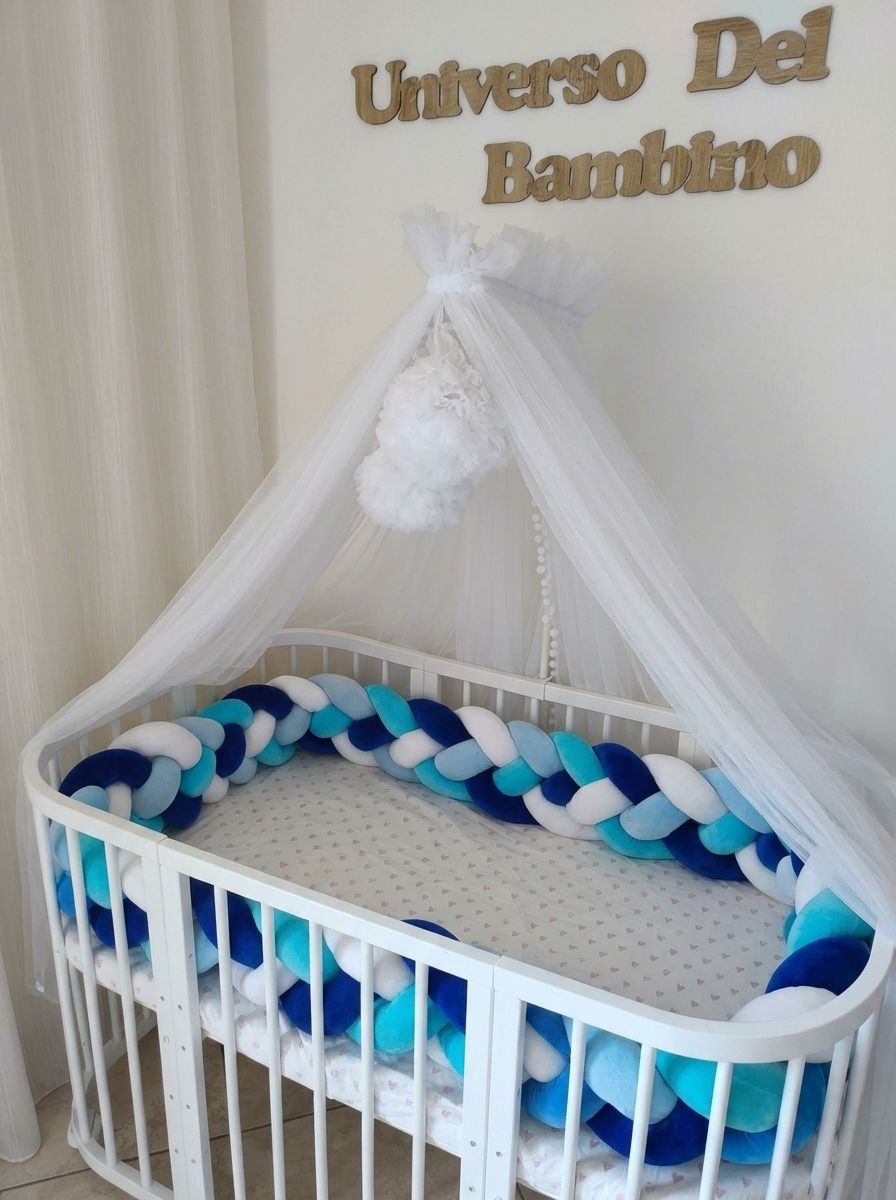 Lettino ovale con treccia paracolpi a 4 fili blu royal, turchese, azzurro e bianco lungo tutto il perimetro e baldacchino in tulle bianco