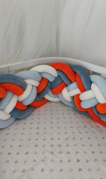 Treccia paracolpi alta a 8 fili arancio, blu e azzurro che segue la curva del lettino ovale