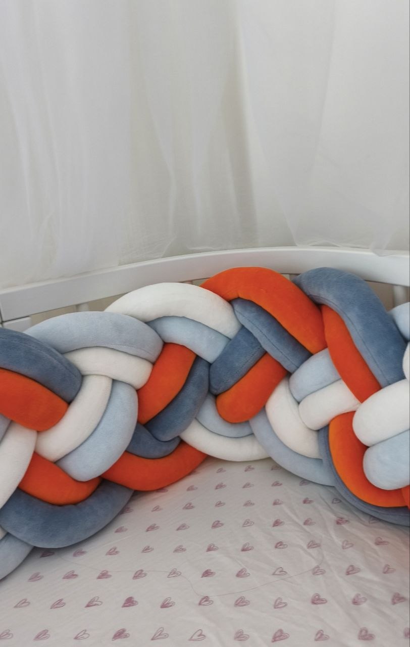 Dettaglio dell'intreccio a 8 fili della treccia paracolpi in velluto arancio, blu, azzurro e bianco