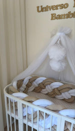 Lettino ovale con treccia paracolpi a 8 fili beige e bianco alta 30-32 cm e velo baldacchino nella cameretta Universo del Bambino