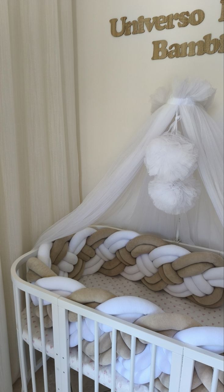 Lettino ovale con treccia paracolpi a 8 fili beige e bianco alta 30-32 cm e velo baldacchino nella cameretta Universo del Bambino