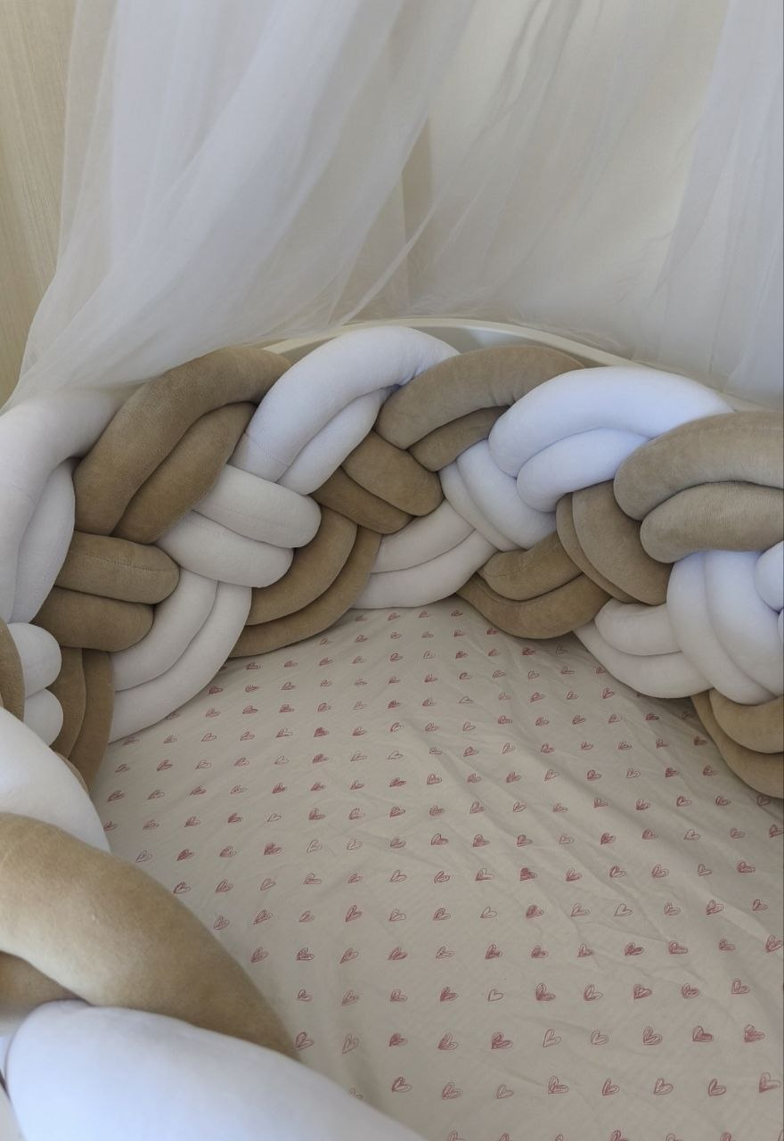 Dettaglio dell'intreccio a 8 fili della treccia paracolpi in velluto beige e bianco dentro il lettino
