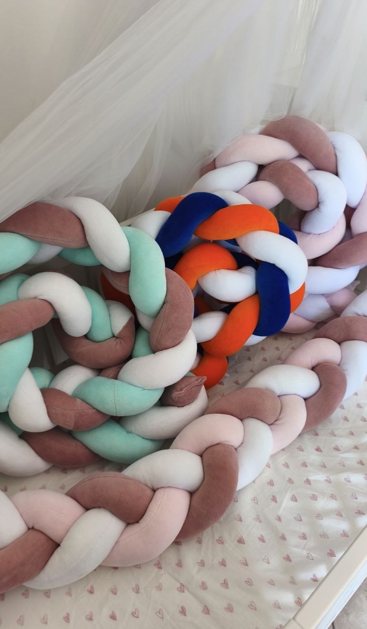 Trecce paracolpi in velluto nei colori menta, rosa antico e bianco e blu, arancione e bianco, una sopra l'altra