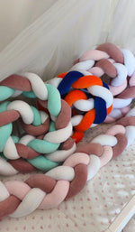 Trecce paracolpi in velluto nei colori menta, rosa antico e bianco e blu, arancione e bianco, una sopra l'altra