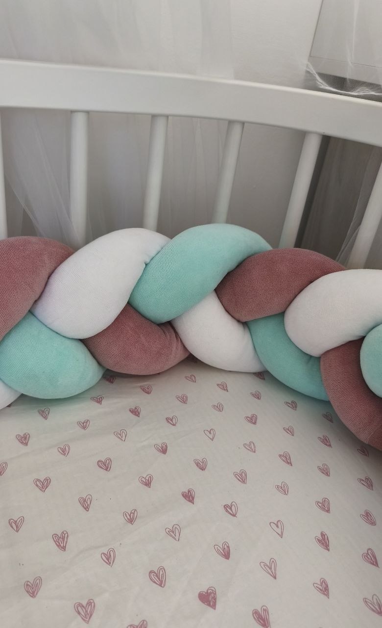 Treccia paracolpi menta, rosa antico e bianco montata lungo le sponde del lettino bianco